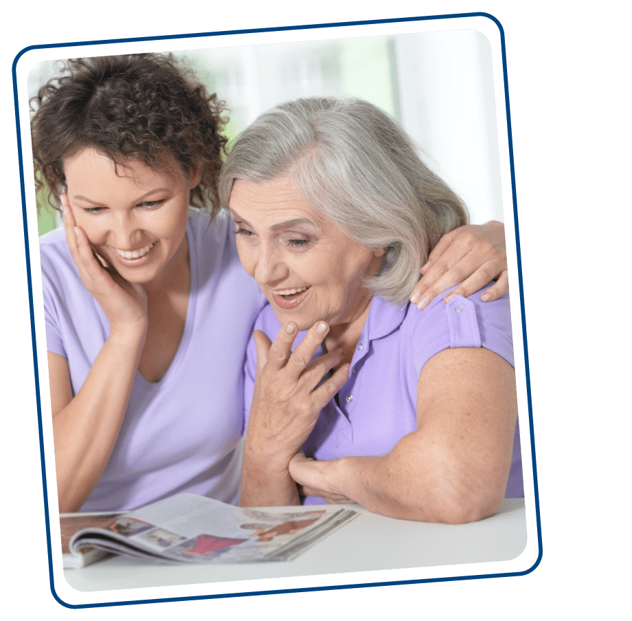 Caregiver daughter with Medicaid patient mother reading magazine